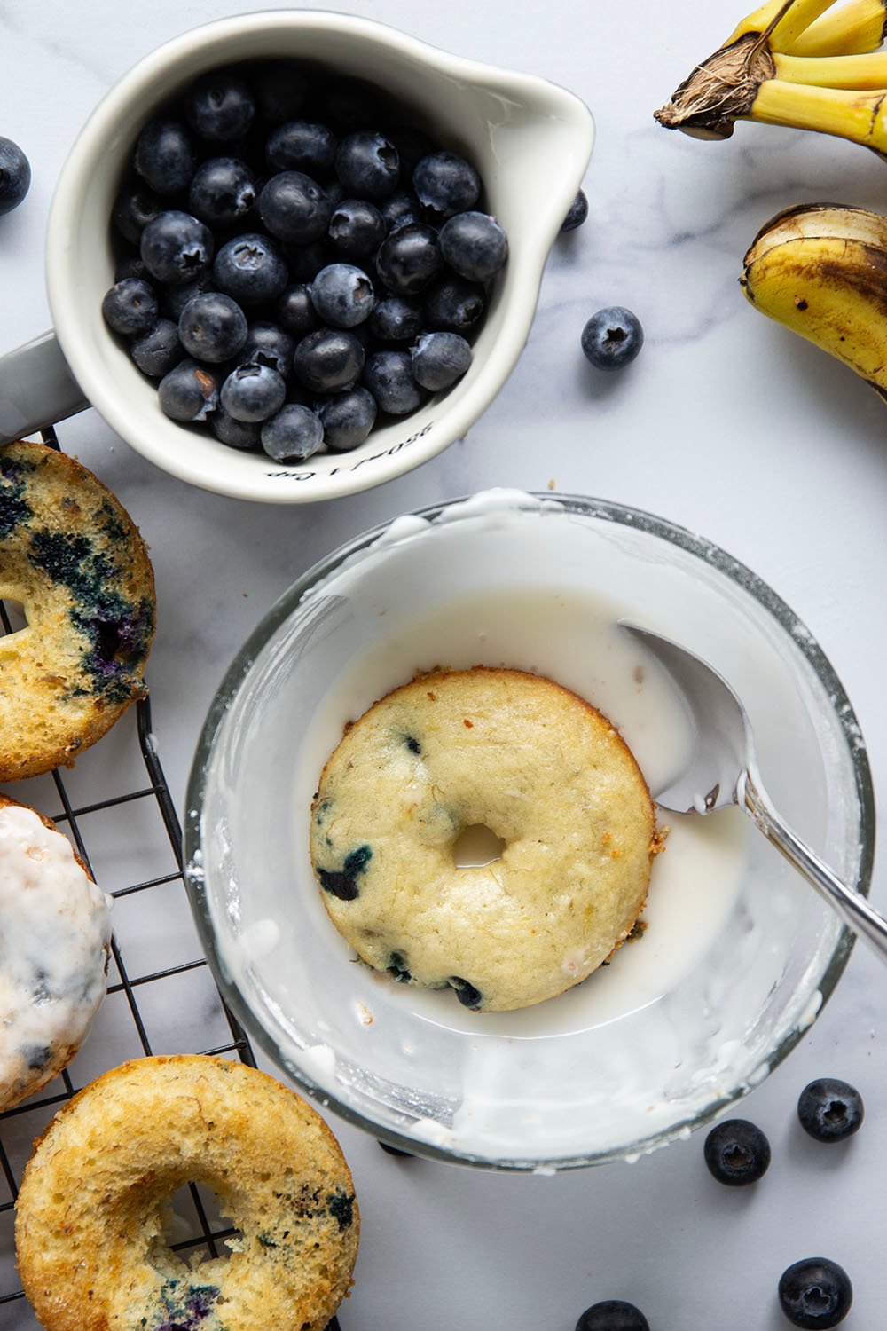These blueberry banana donuts are incredibly moist inside, studded with juicy blueberries, and dipped in lots of creamy vanilla glaze.