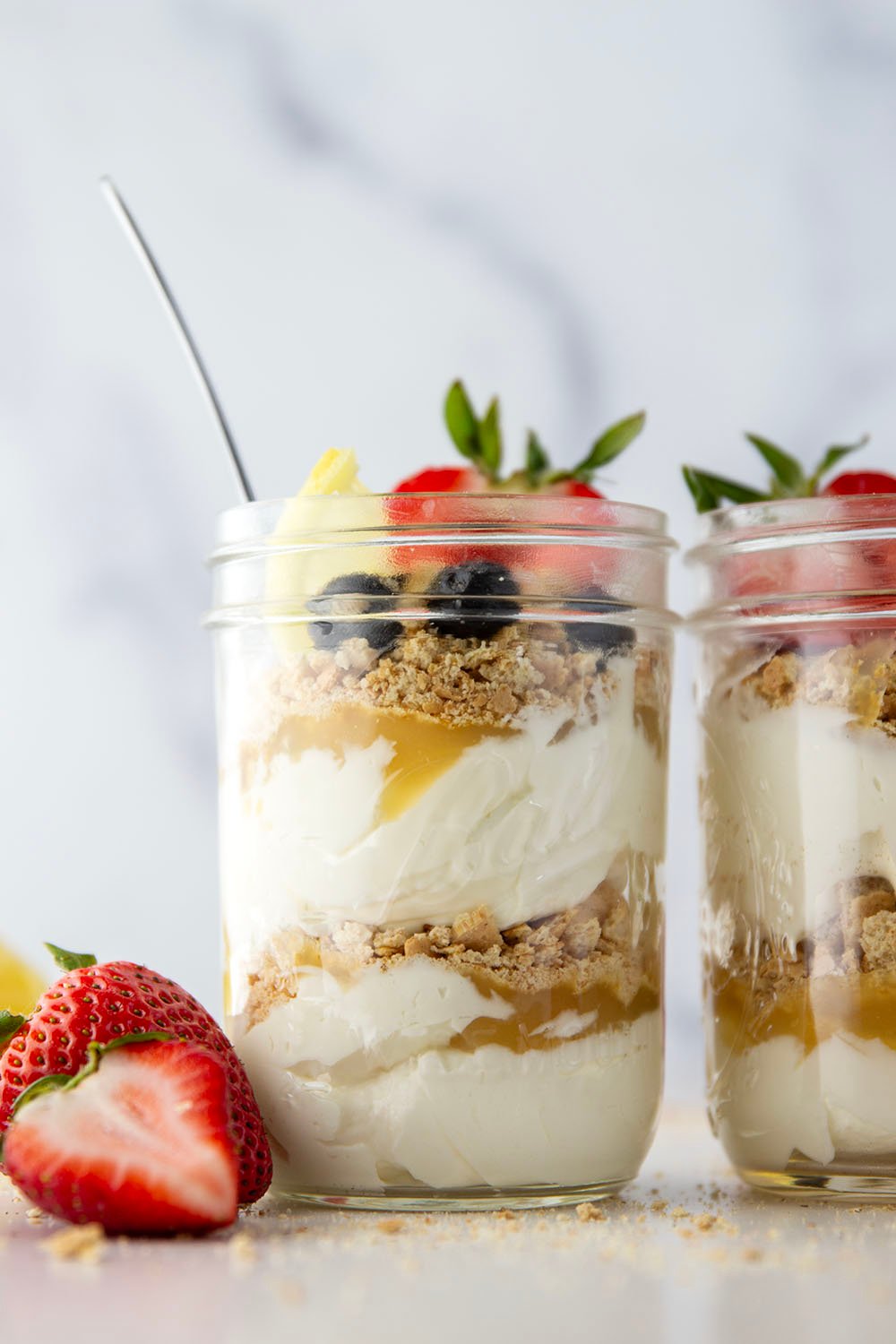 Layers upon layers of luscious lemon cheesecake, graham crackers, and lemon curd star in these no bake lemon cheesecake parfaits!