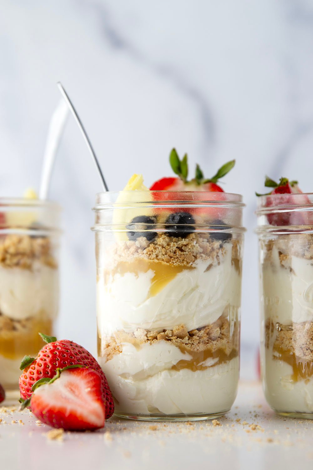 Layers upon layers of luscious lemon cheesecake, graham crackers, and lemon curd star in these no bake lemon cheesecake parfaits!