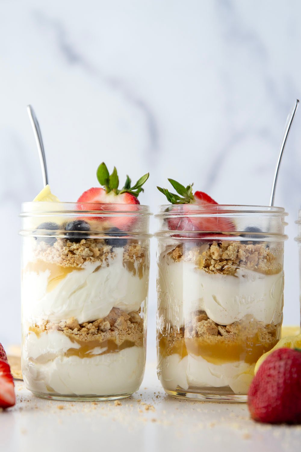 Layers upon layers of luscious lemon cheesecake, graham crackers, and lemon curd star in these no bake lemon cheesecake parfaits!