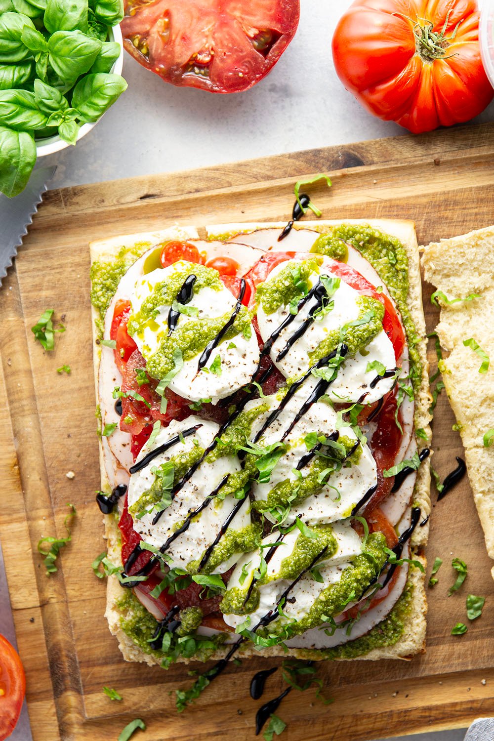 These caprese sliders feature herby basil pesto, sliced turkey, creamy burrata, and lots of fresh tomato slices layered between soft slider buns.