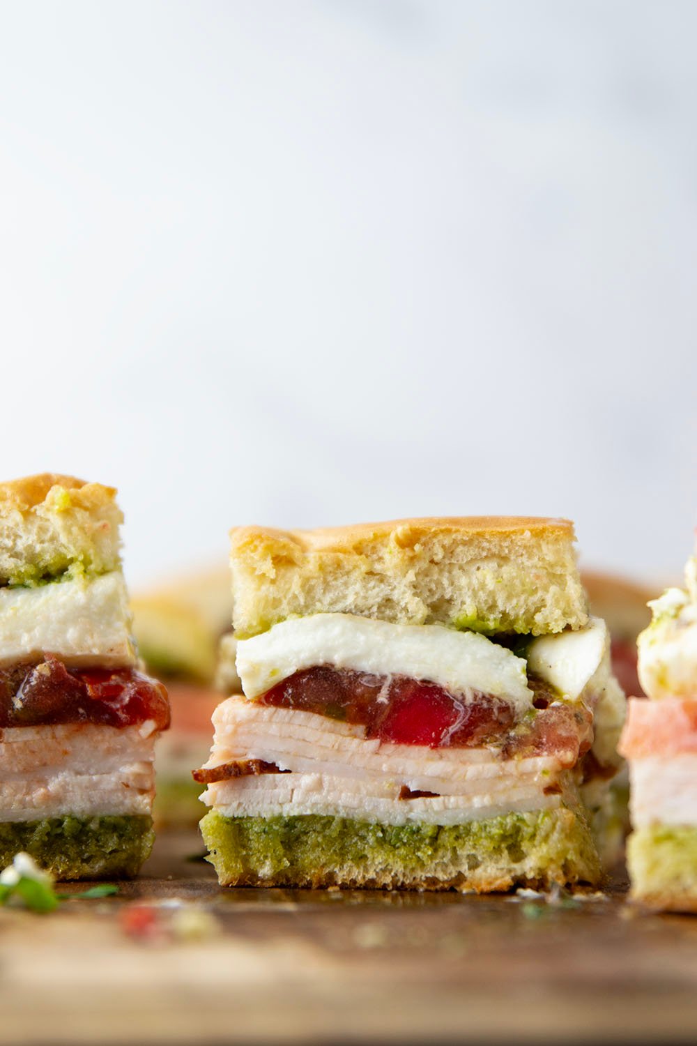 These caprese sliders feature herby basil pesto, sliced turkey, creamy burrata, and lots of fresh tomato slices layered between soft slider buns.