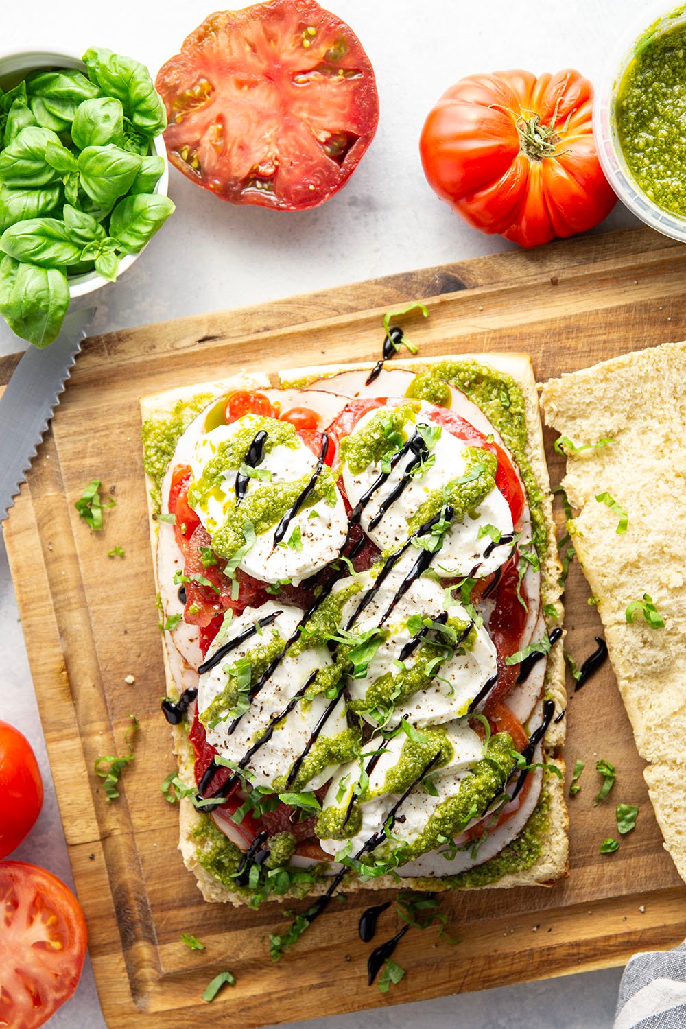 These caprese sliders feature herby basil pesto, sliced turkey, creamy burrata, and lots of fresh tomato slices layered between soft slider buns.
