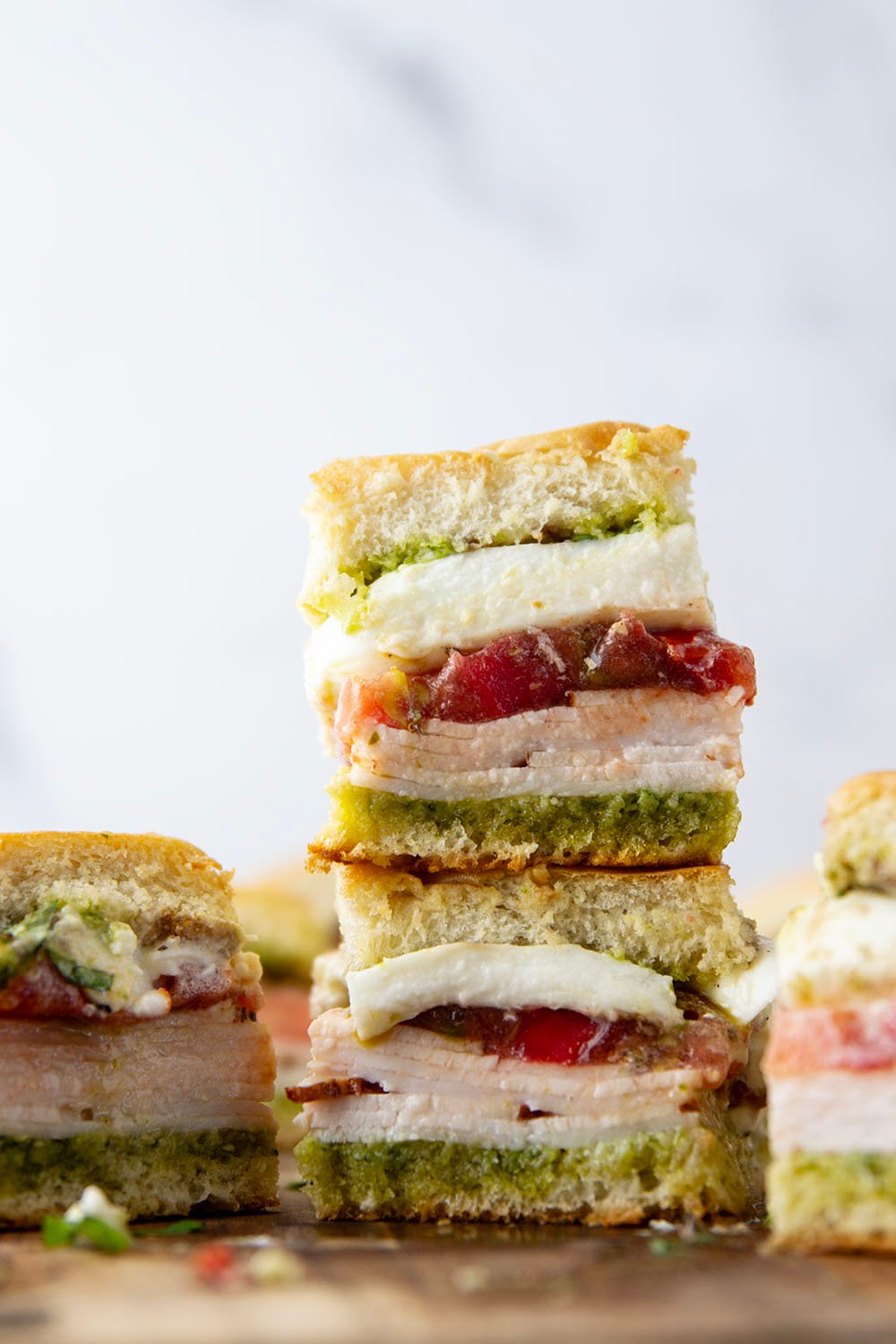 These caprese sliders feature herby basil pesto, sliced turkey, creamy burrata, and lots of fresh tomato slices layered between soft slider buns.