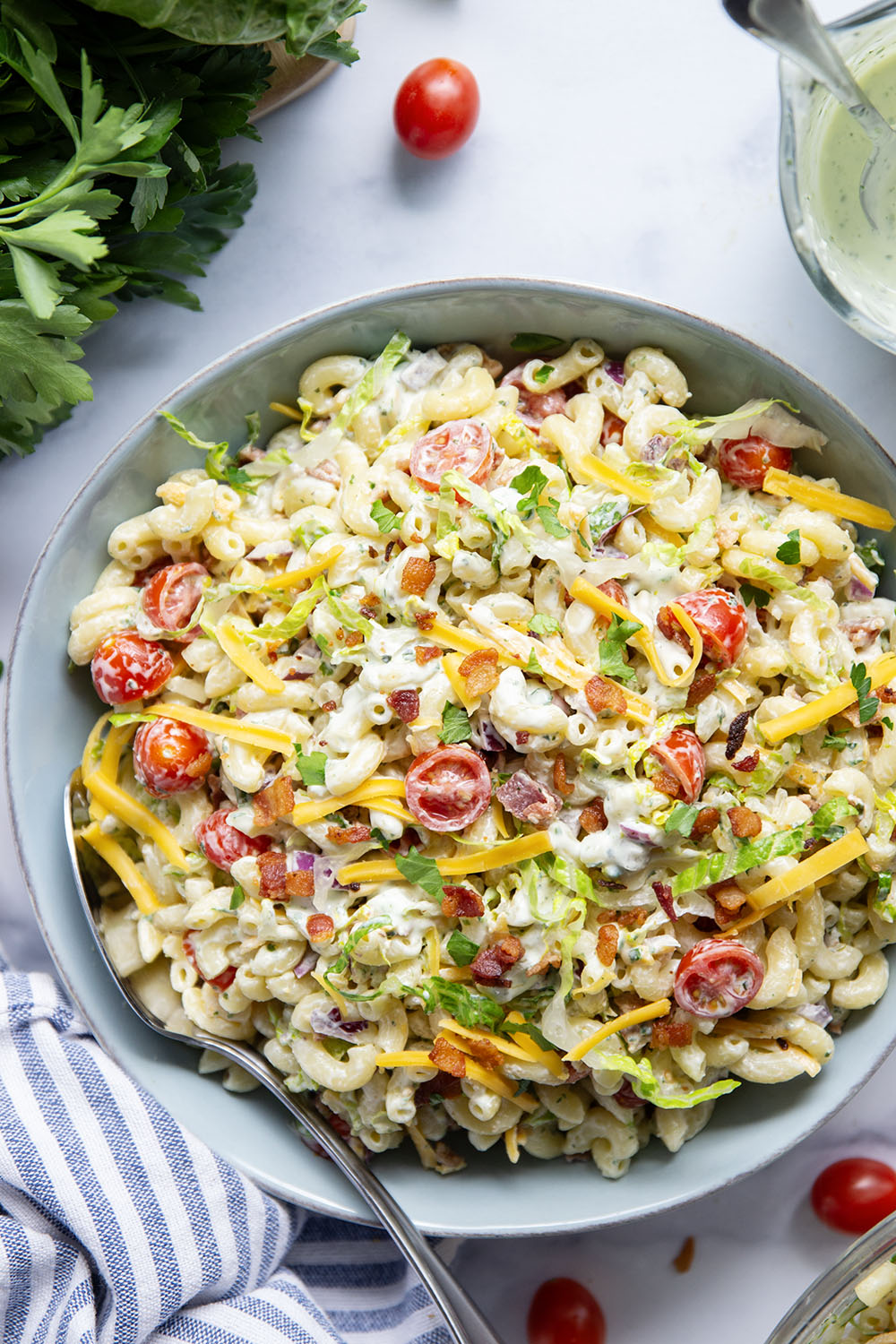 This BLT macaroni salad is packed with crispy bacon, shredded lettuce, juicy tomatoes, lots of shredded cheddar, and tossed in a perfectly creamy homemade herb ranch dressing.