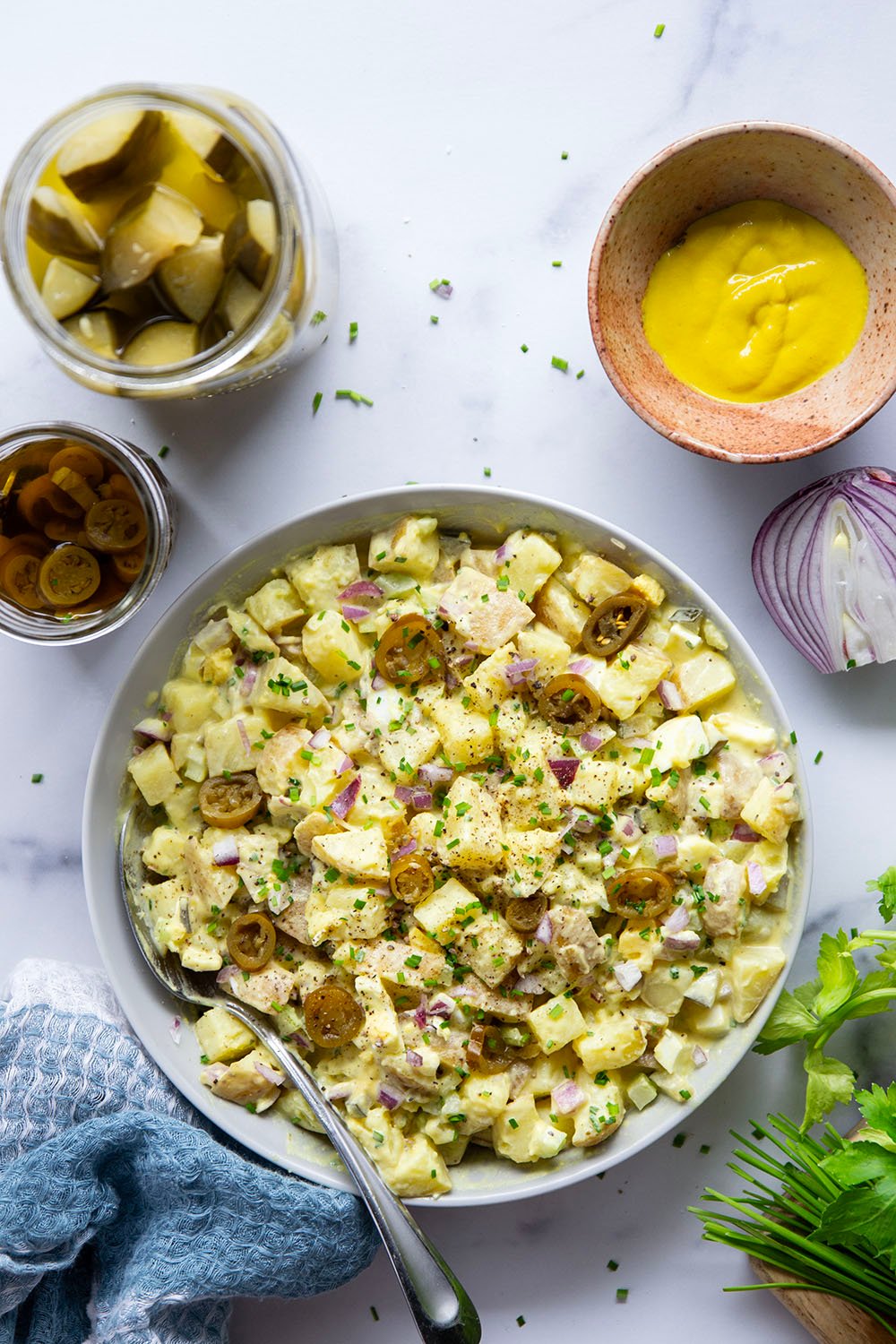 Texas potato salad features a tangy yellow mustard dressing coating tender potatoes with lots of pickled jalapenos for a kick of heat.