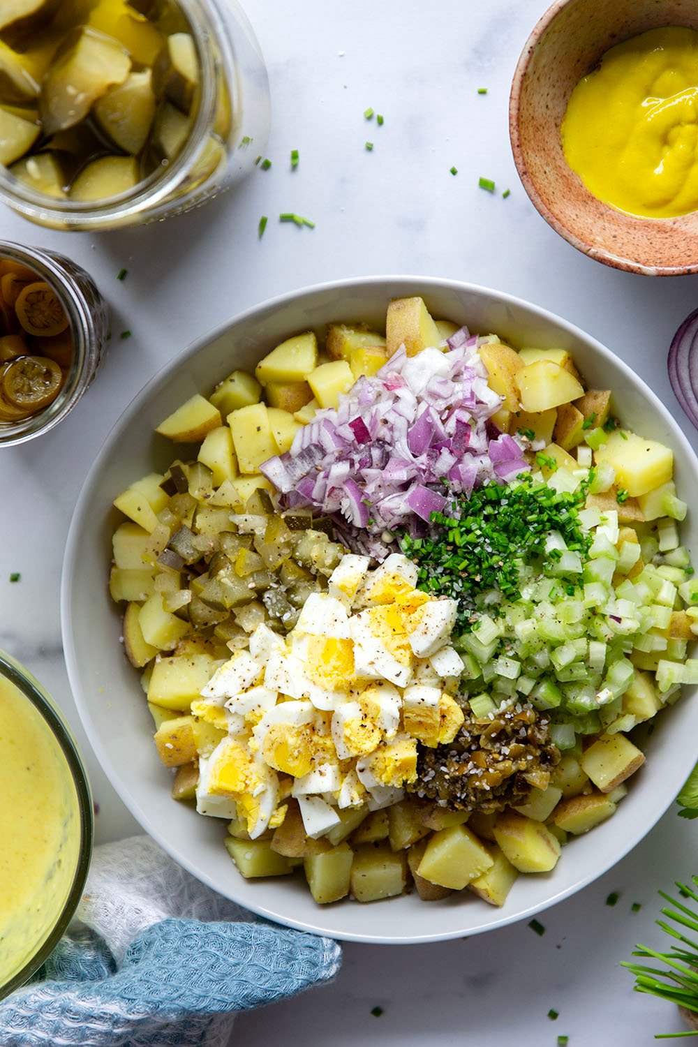 Texas potato salad features a tangy yellow mustard dressing coating tender potatoes with lots of pickled jalapenos for a kick of heat.