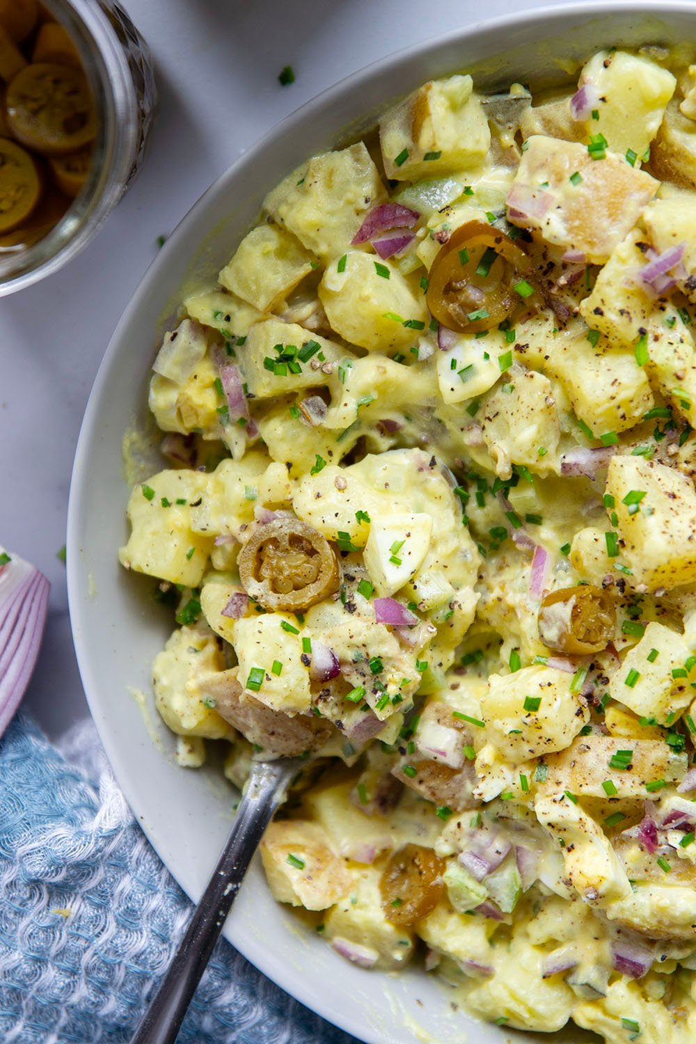 Texas potato salad features a tangy yellow mustard dressing coating tender potatoes with lots of pickled jalapenos for a kick of heat.