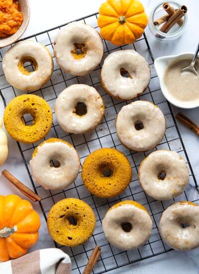 Super soft and fluffy baked pumpkin donuts are dipped in a rich cream cheese glaze and perfect for any fall occasion.