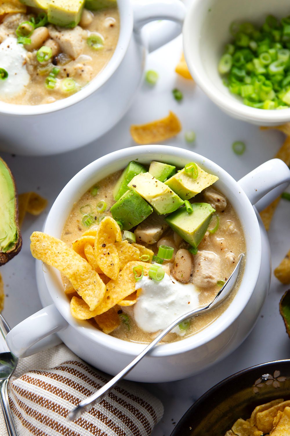 This white chicken chili is the ultimate comfort food! Loaded with lots of tender chicken and beans in a rich broth and piled high with all the toppings.