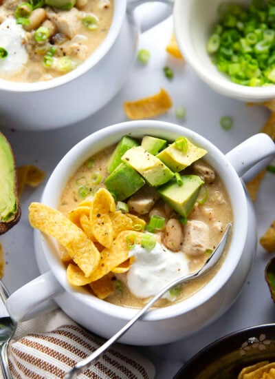 This white chicken chili is the ultimate comfort food! Loaded with lots of tender chicken and beans in a rich broth and piled high with all the toppings.