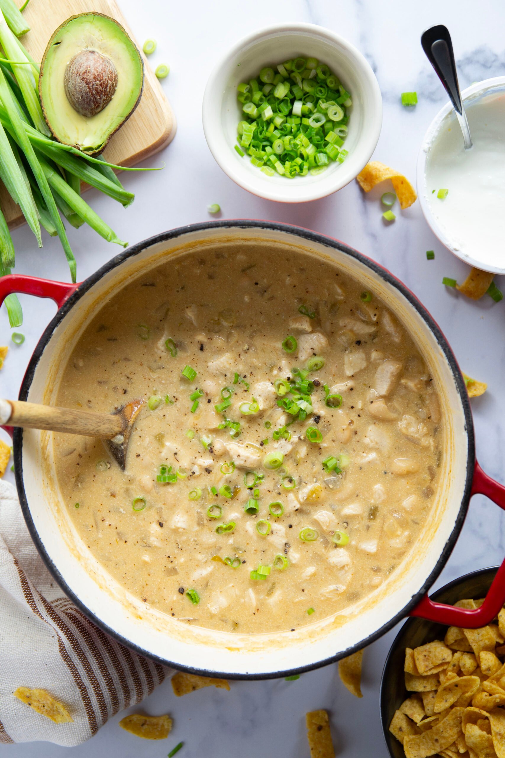 This white chicken chili is the ultimate comfort food! Loaded with lots of tender chicken and beans in a rich broth and piled high with all the toppings.