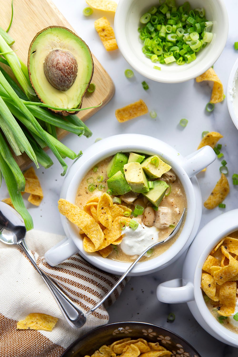 This white chicken chili is the ultimate comfort food! Loaded with lots of tender chicken and beans in a rich broth and piled high with all the toppings.