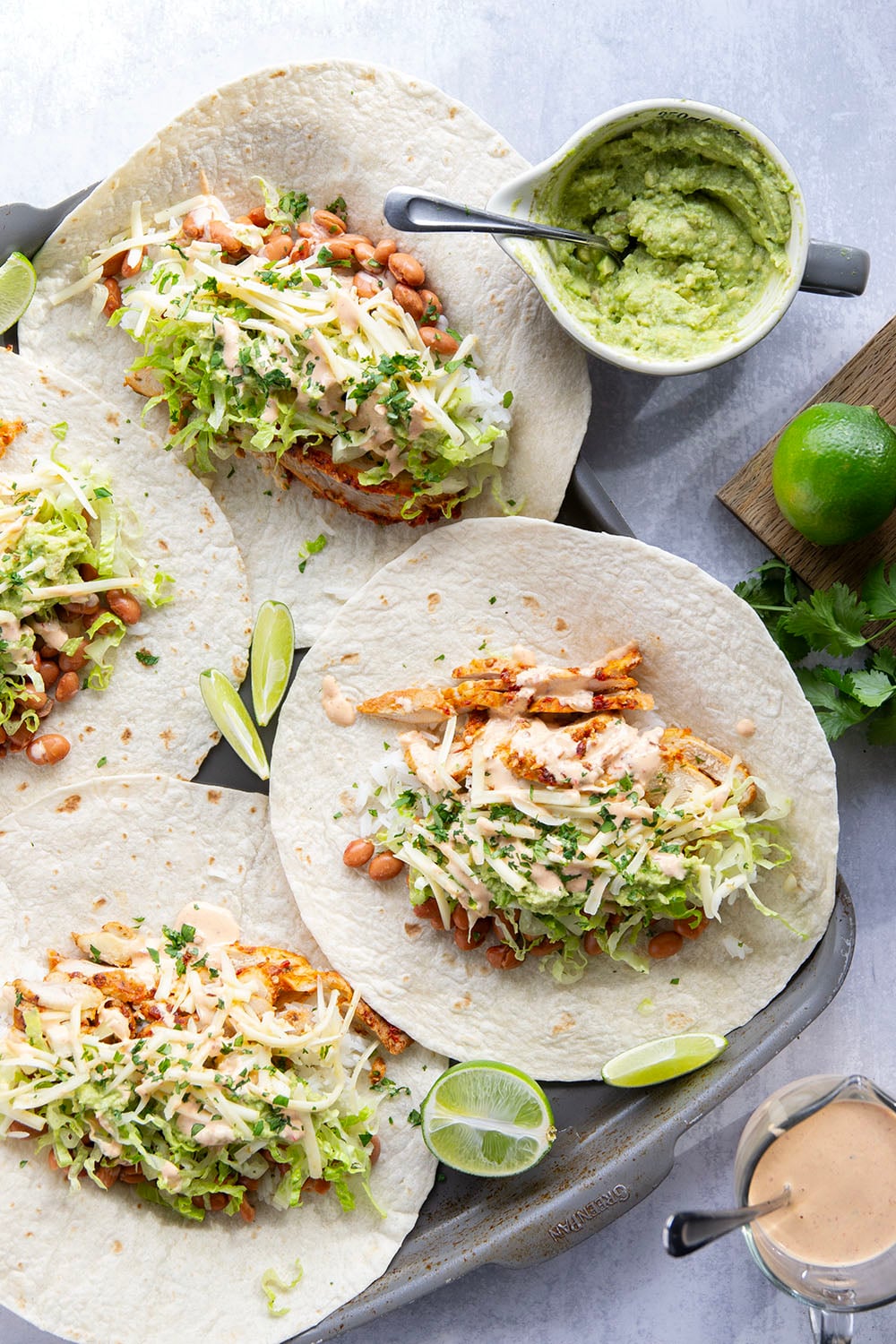 These chipotle chicken burritos feature spicy chipotle marinated chicken, fluffy rice, pinto beans, shredded lettuce, and a creamy chipotle sauce layered in soft flour tortillas.