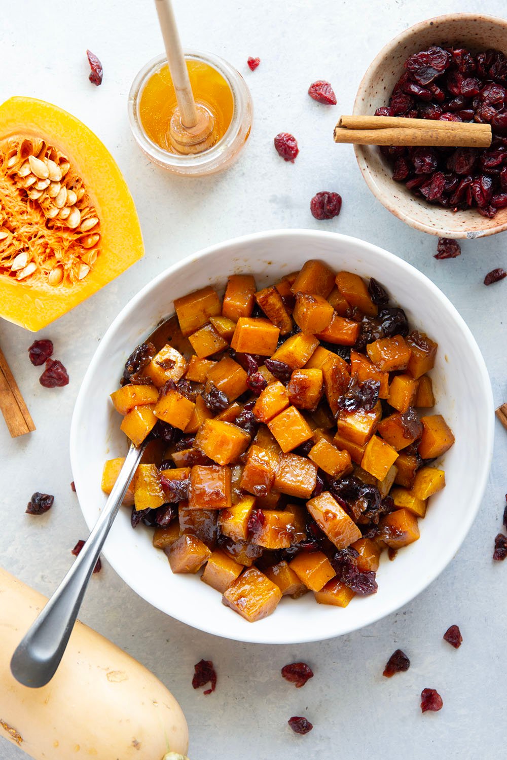 Roasted in a sweet spiced honey glaze and tossed with dried cranberries, this honey roasted butternut squash is an easy fall side dish that comes together in minutes!
