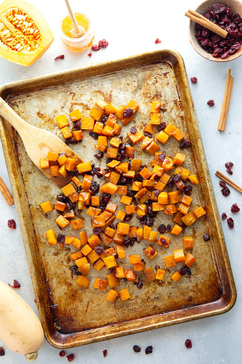 Roasted in a sweet spiced honey glaze and tossed with dried cranberries, this honey roasted butternut squash is an easy fall side dish that comes together in minutes!