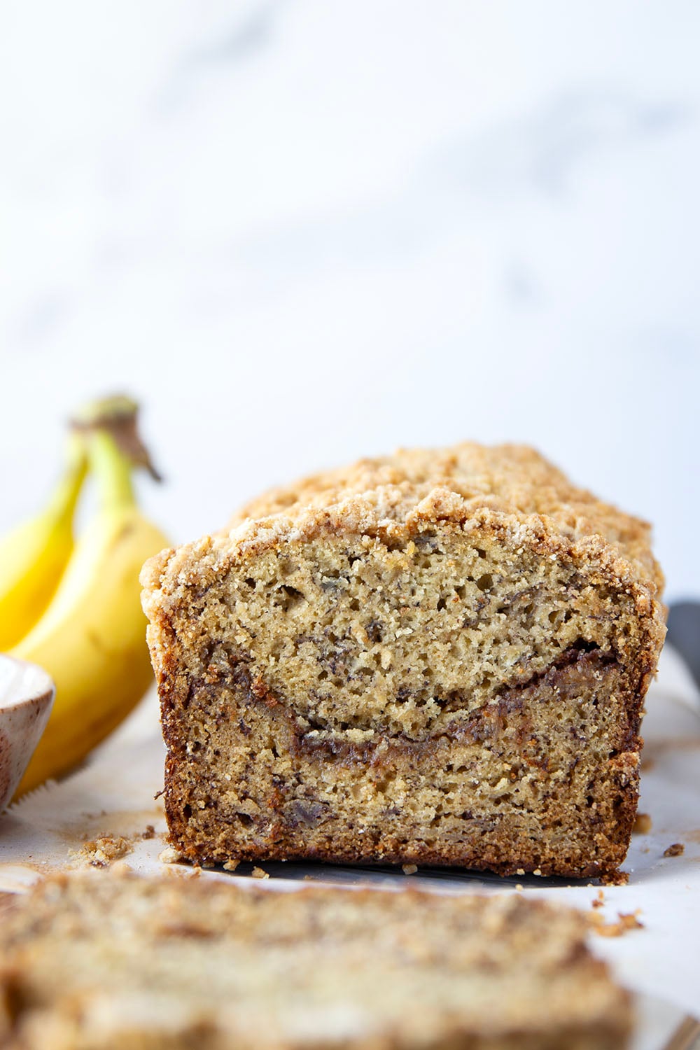 Coffee cake and banana bread collide into one irresistible loaf! This coffee cake banana bread features a soft texture with a cinnamon sugar ribbon in the center and lots of crunchy streusel baked on top.