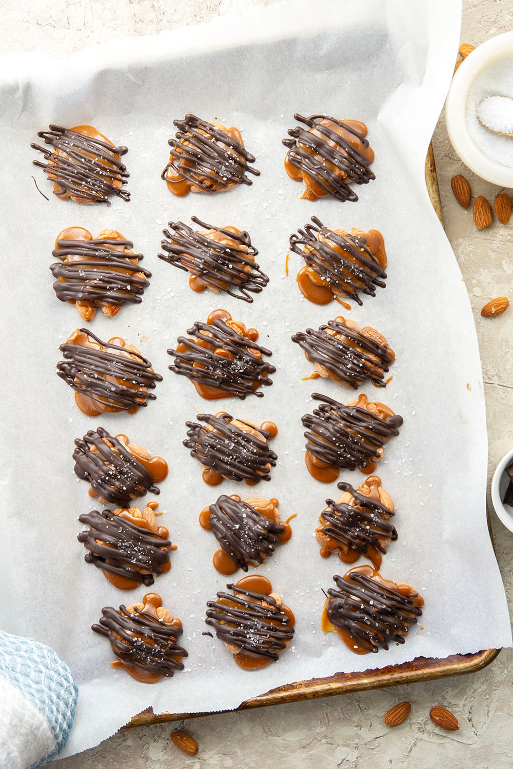 Roasted almonds, homemade caramel, and a good drizzle of dark chocolate come together in these dark chocolate almond clusters that whip up in minutes.