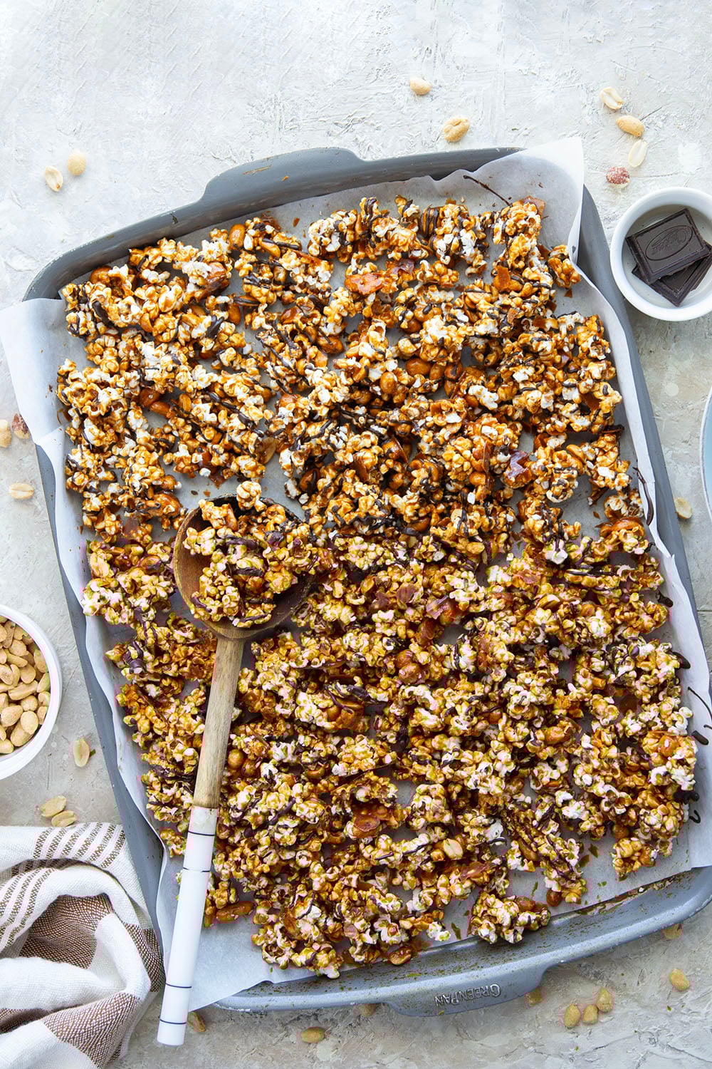 Covered in melted chocolate and caramel sauce and loaded with crunchy peanuts, this addicting caramel corn is the ultimate sweet snack!