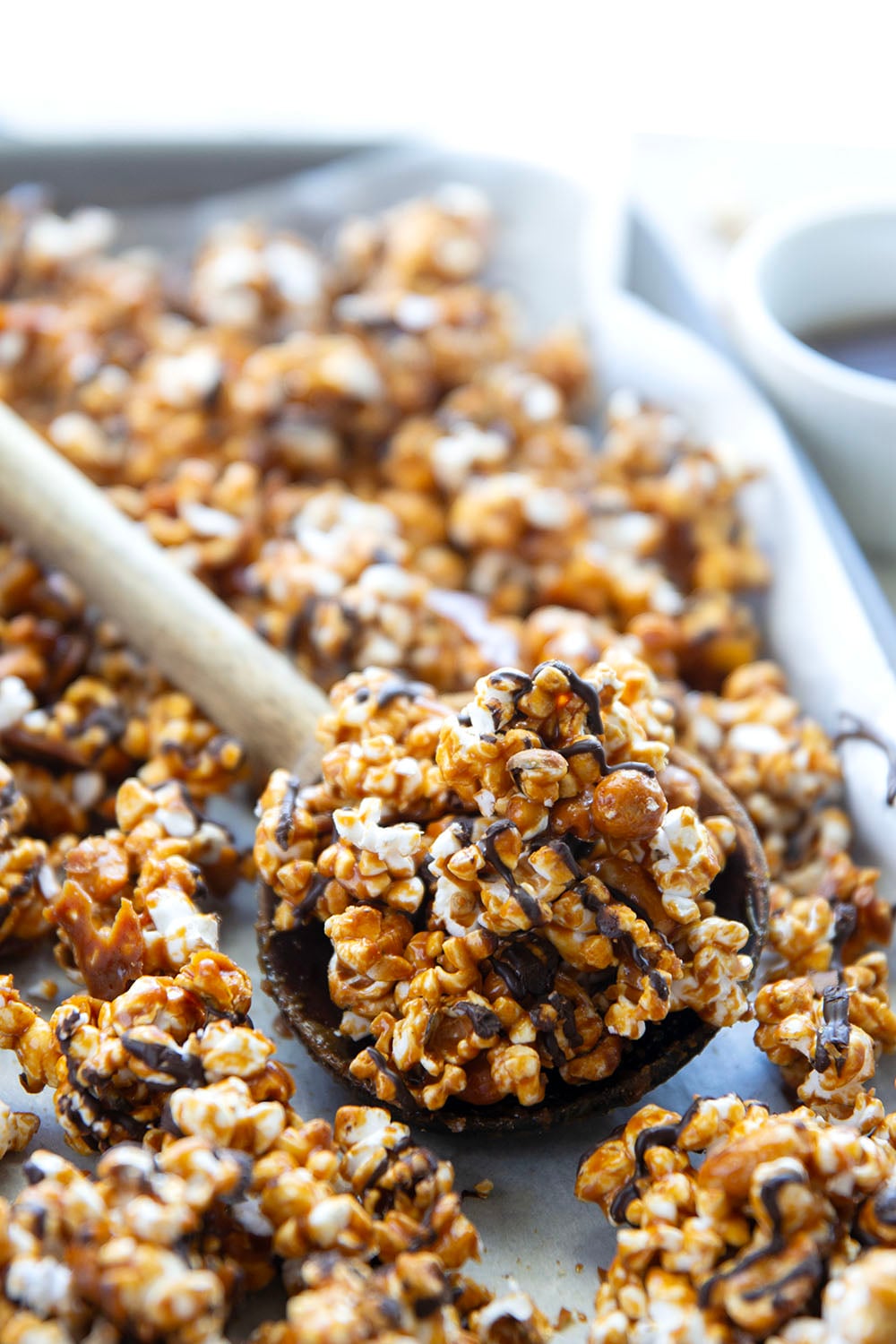 Covered in melted chocolate and caramel sauce and loaded with crunchy peanuts, this addicting caramel corn is the ultimate sweet snack!