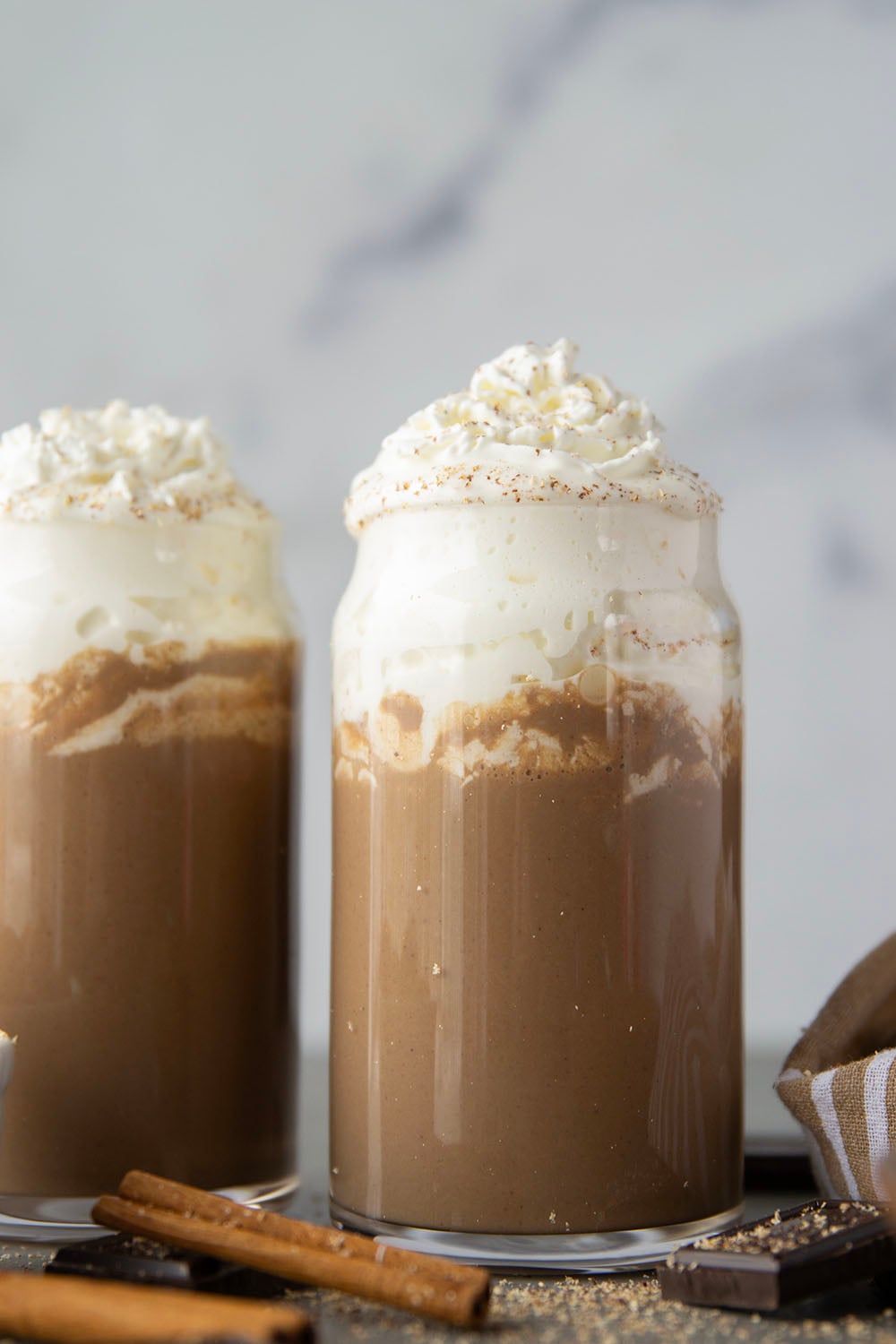 Chase away the winter chill with this eggnog hot chocolate that features winter spices, rich eggnog, and sweet hot chocolate all in one drink! Enjoy this easy holiday sipper hot or cold with lots of whipped cream on top.