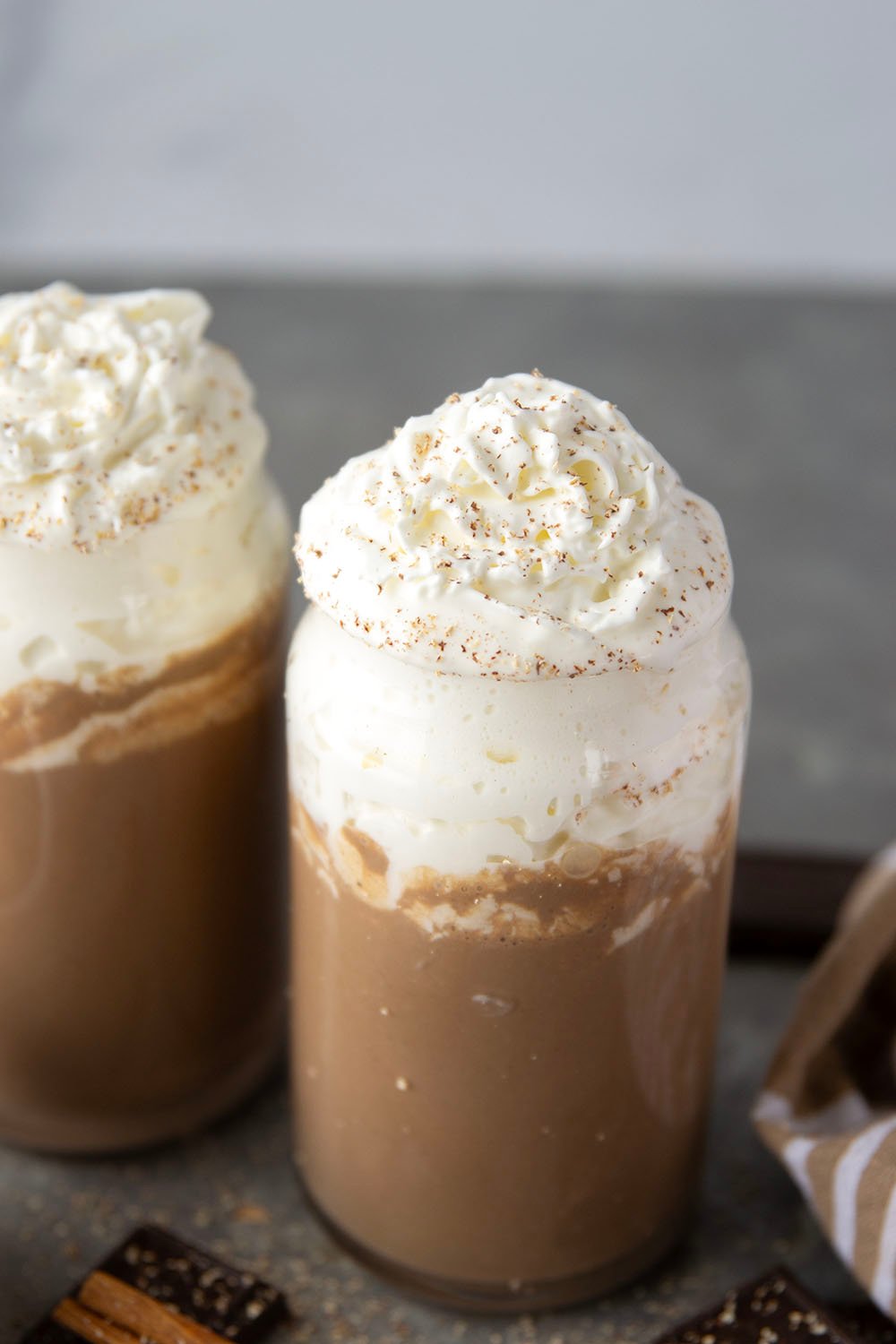 Chase away the winter chill with this eggnog hot chocolate that features winter spices, rich eggnog, and sweet hot chocolate all in one drink! Enjoy this easy holiday sipper hot or cold with lots of whipped cream on top.