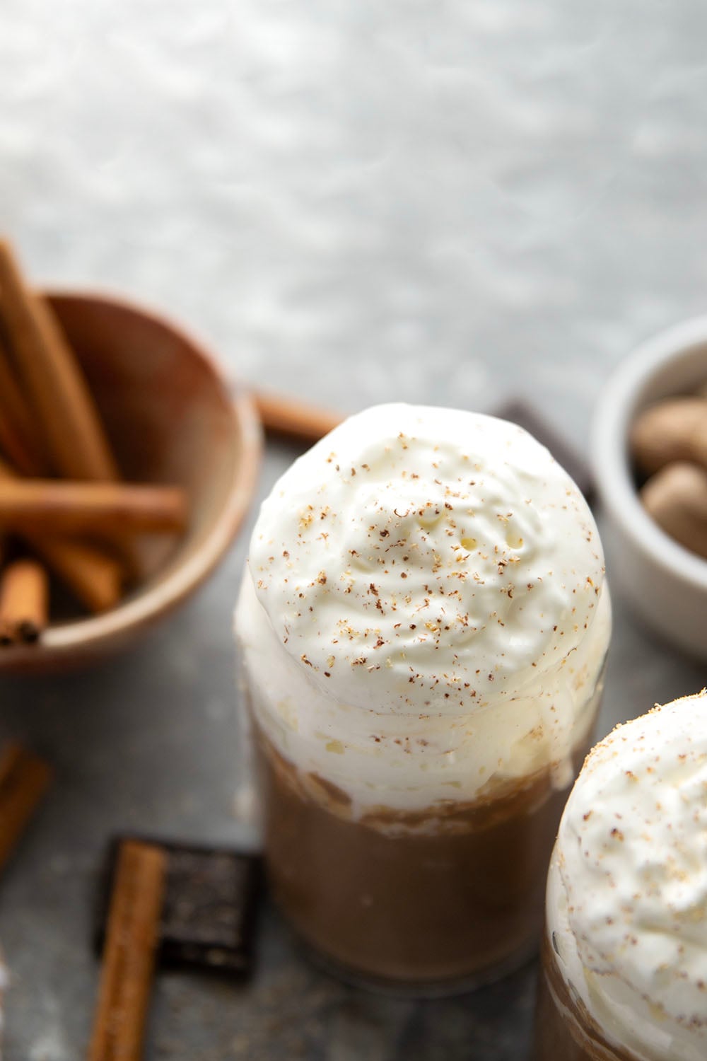 Chase away the winter chill with this eggnog hot chocolate that features winter spices, rich eggnog, and sweet hot chocolate all in one drink! Enjoy this easy holiday sipper hot or cold with lots of whipped cream on top.