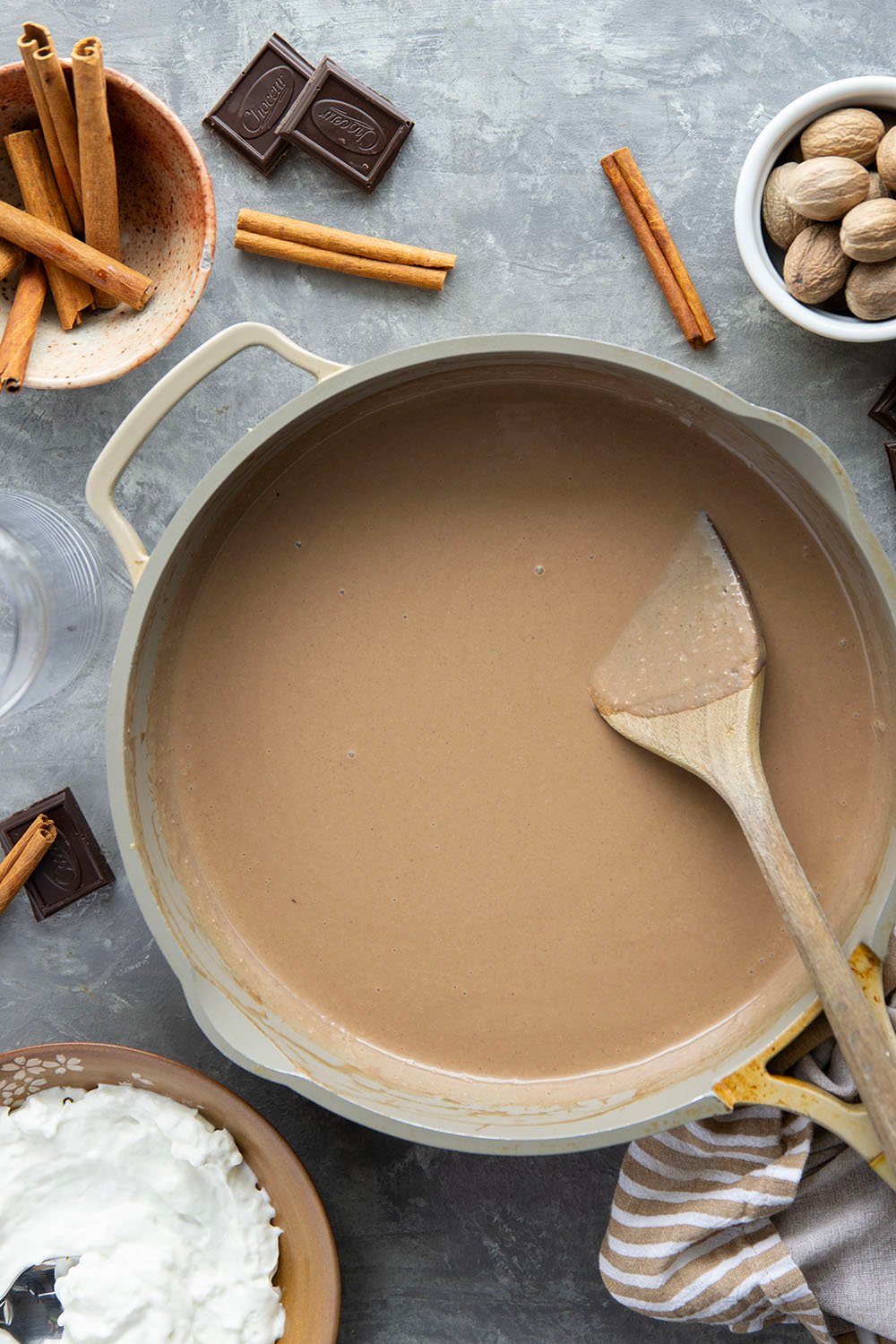 Chase away the winter chill with this eggnog hot chocolate that features winter spices, rich eggnog, and sweet hot chocolate all in one drink! Enjoy this easy holiday sipper hot or cold with lots of whipped cream on top.