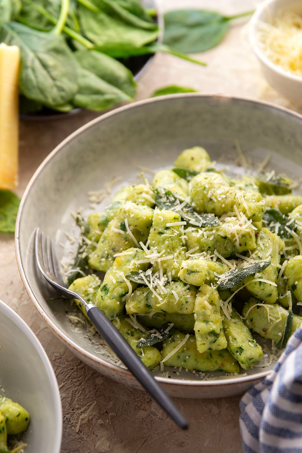 Light and fluffy homemade spinach gnocchi is packed with vibrant fresh spinach and tossed in a sage browned butter and lots of fresh Parmesan.