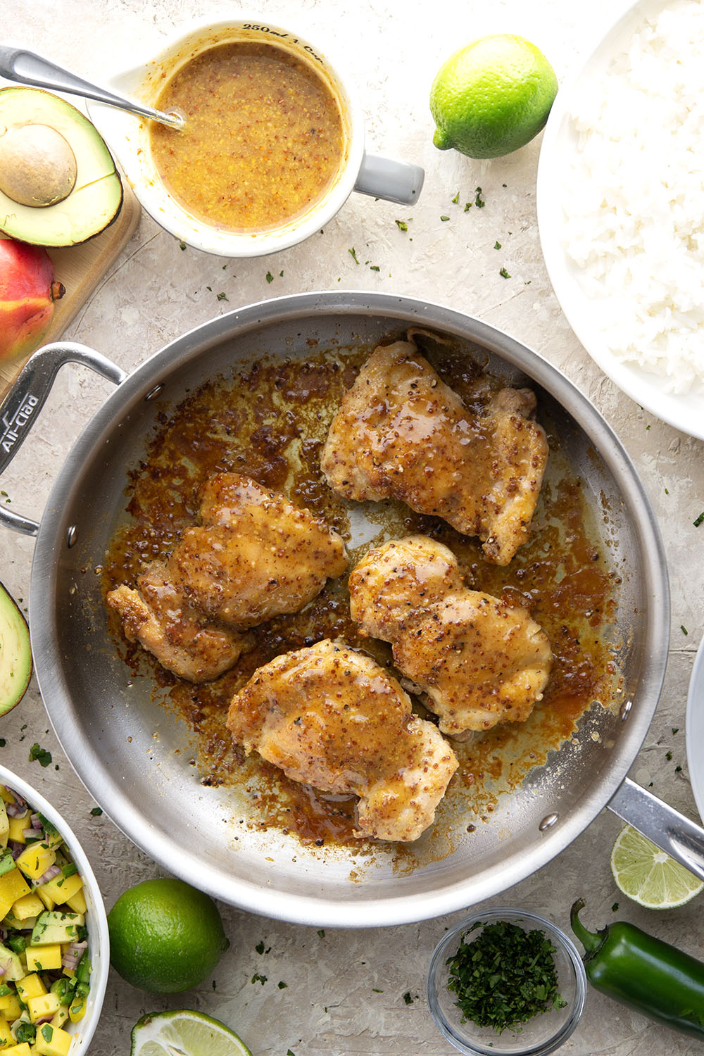 These honey mustard chicken bowls are loaded with so much goodness and you won't believe how quickly they come together! Sweet and tangy honey mustard chicken thighs pair perfectly with fluffy rice and a fresh mango salsa.