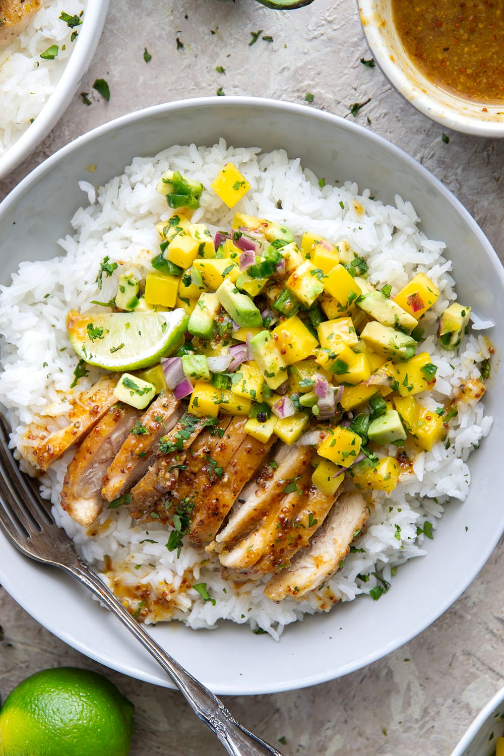 These honey mustard chicken bowls are loaded with so much goodness and you won't believe how quickly they come together! Sweet and tangy honey mustard chicken thighs pair perfectly with fluffy rice and a fresh mango salsa.