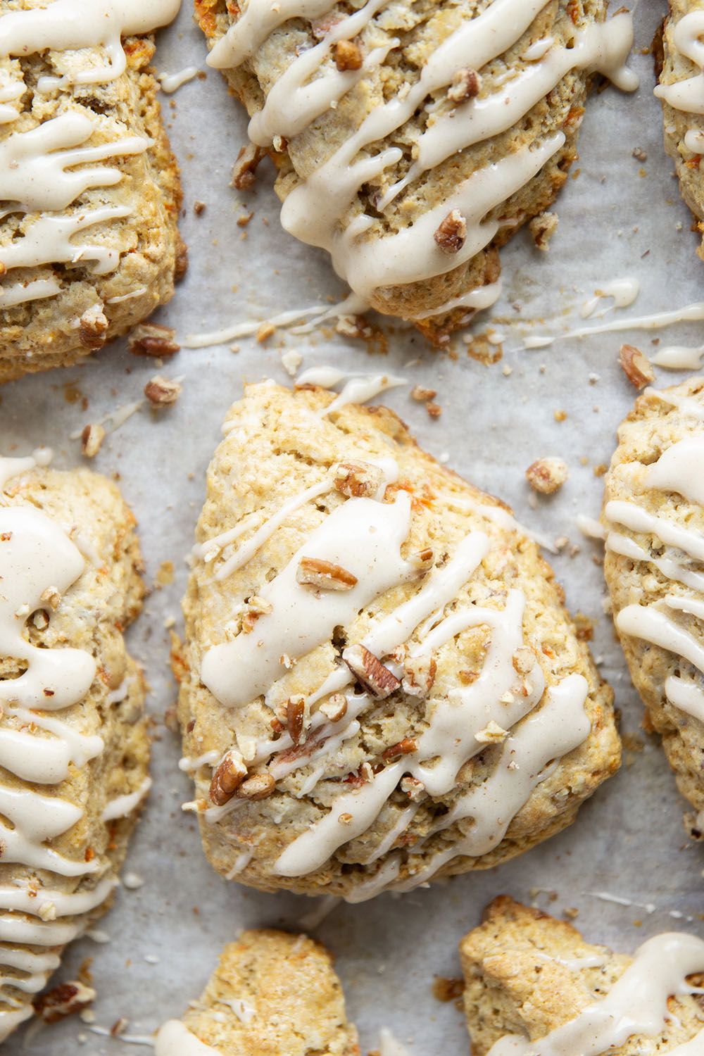 Soft and tender carrot cake scones feature lots of toasted pecans, shredded carrots, and a silky cream cheese glaze drizzled on top.