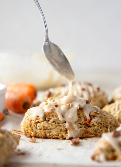 Soft and tender carrot cake scones feature lots of toasted pecans, shredded carrots, and a silky cream cheese glaze drizzled on top.