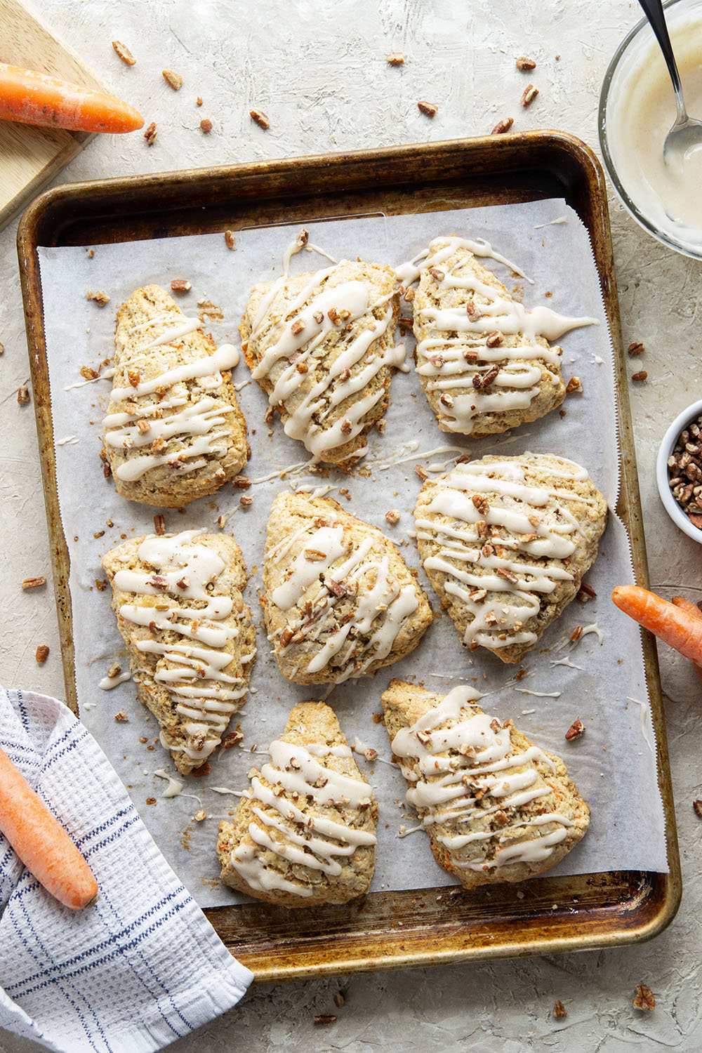 Soft and tender carrot cake scones feature lots of toasted pecans, shredded carrots, and a silky cream cheese glaze drizzled on top.
