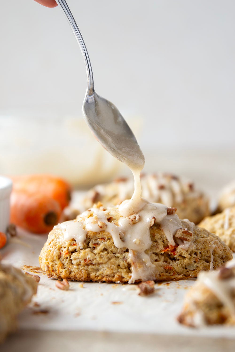 Soft and tender carrot cake scones feature lots of toasted pecans, shredded carrots, and a silky cream cheese glaze drizzled on top.