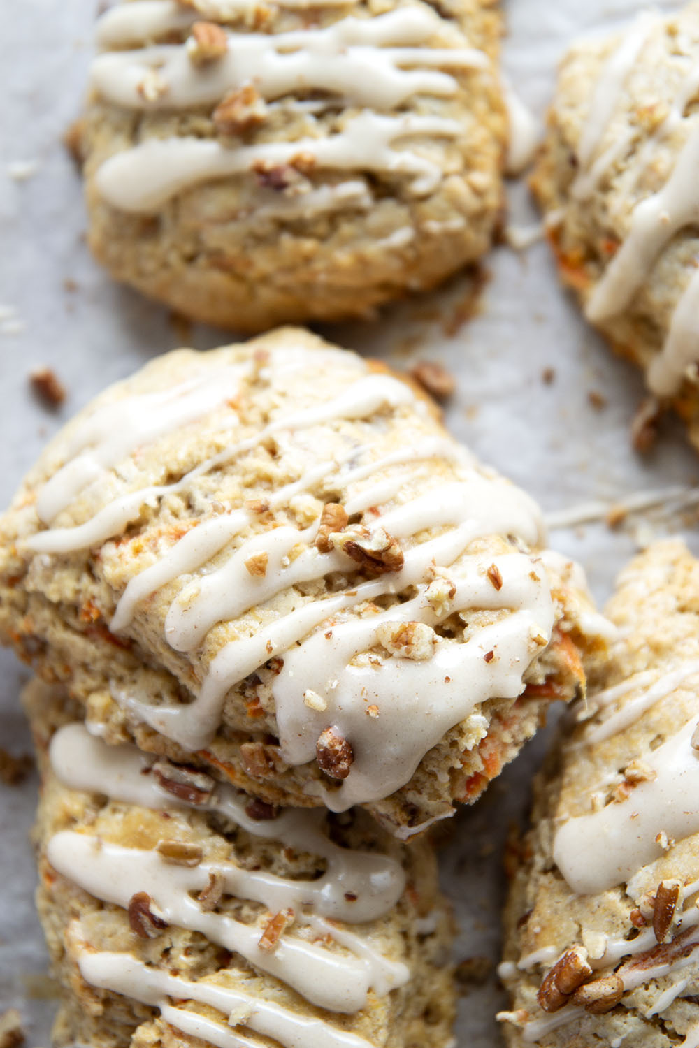Soft and tender carrot cake scones feature lots of toasted pecans, shredded carrots, and a silky cream cheese glaze drizzled on top.