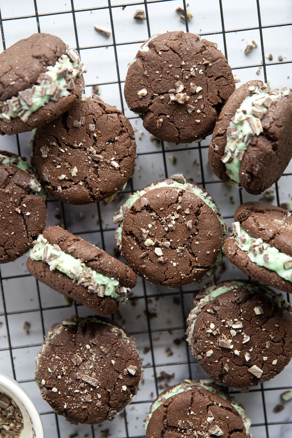 These mint chocolate sandwich cookies feature rich chocolate cookies with a creamy mint buttercream sandwiched between and rolled in lots of chopped Andes candies.