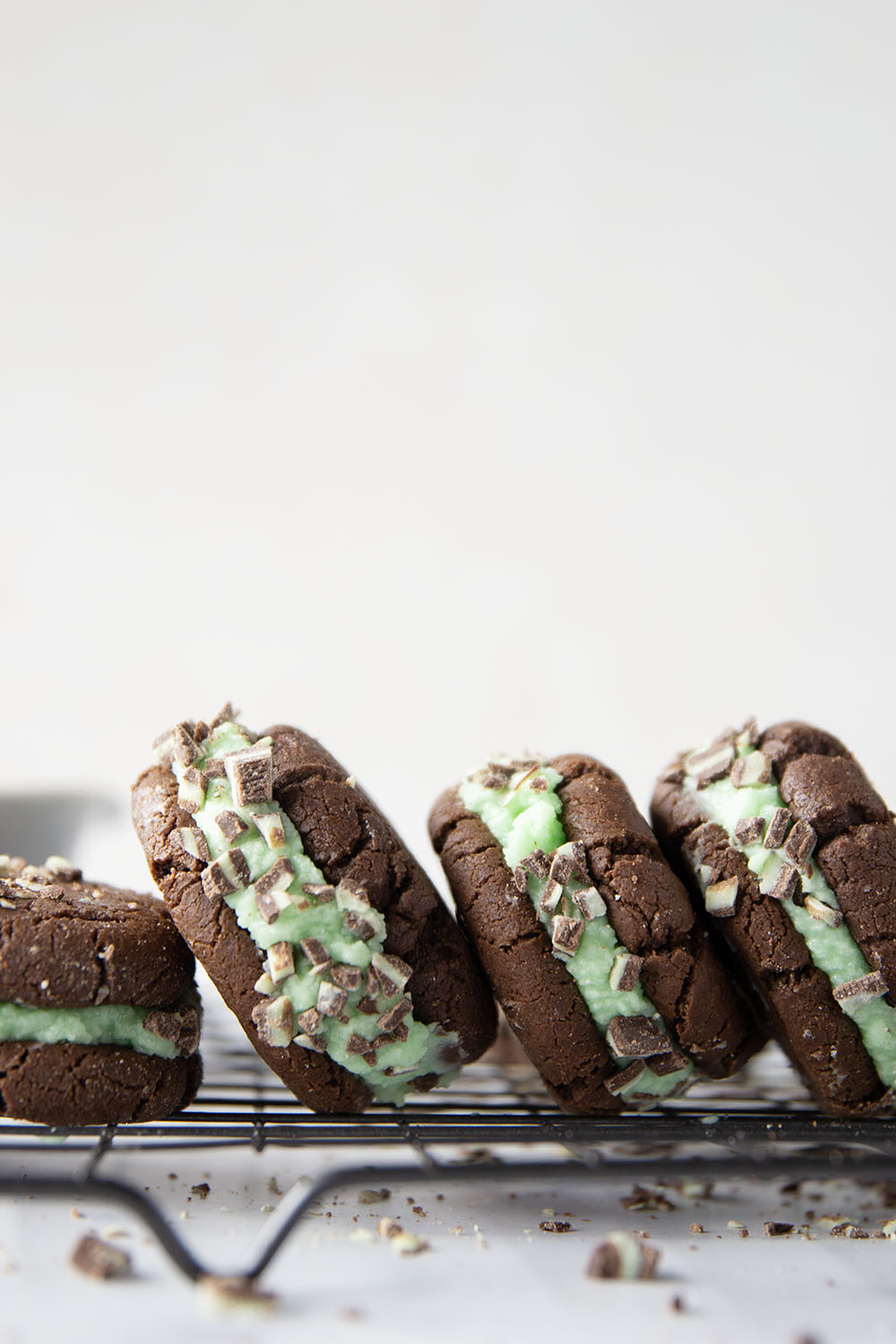 These mint chocolate sandwich cookies feature rich chocolate cookies with a creamy mint buttercream sandwiched between and rolled in lots of chopped Andes candies.