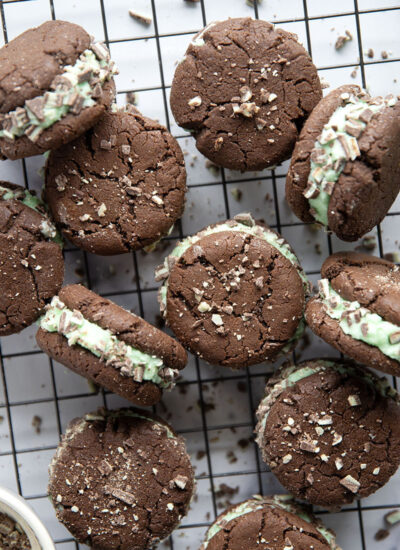 These mint chocolate sandwich cookies feature rich chocolate cookies with a creamy mint buttercream sandwiched between and rolled in lots of chopped Andes candies.