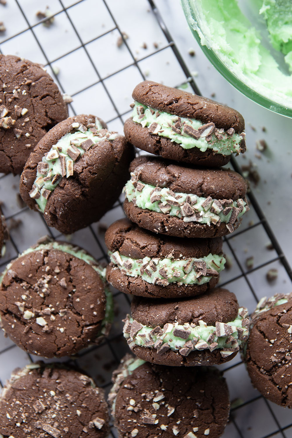 These mint chocolate sandwich cookies feature rich chocolate cookies with a creamy mint buttercream sandwiched between and rolled in lots of chopped Andes candies.