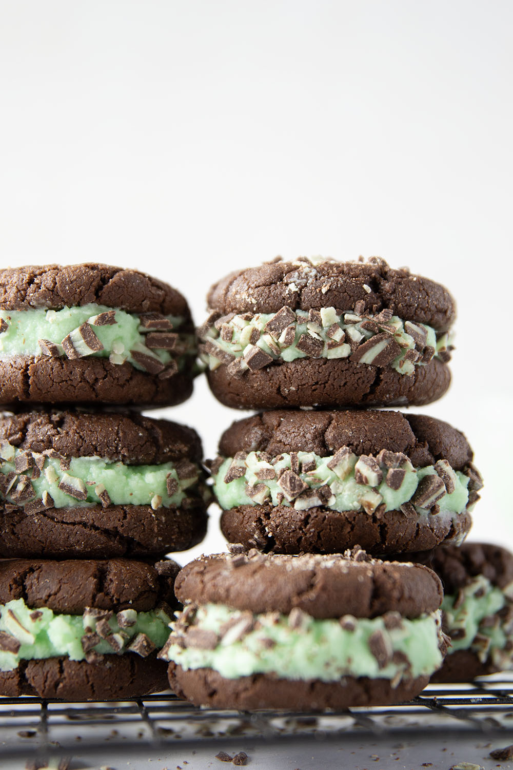 These mint chocolate sandwich cookies feature rich chocolate cookies with a creamy mint buttercream sandwiched between and rolled in lots of chopped Andes candies.