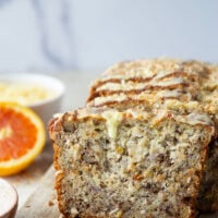 This tropical banana bread features a perfectly soft and dense texture and is packed with flaked coconut, lots of pineapple, and topped with a sweet citrus glaze.