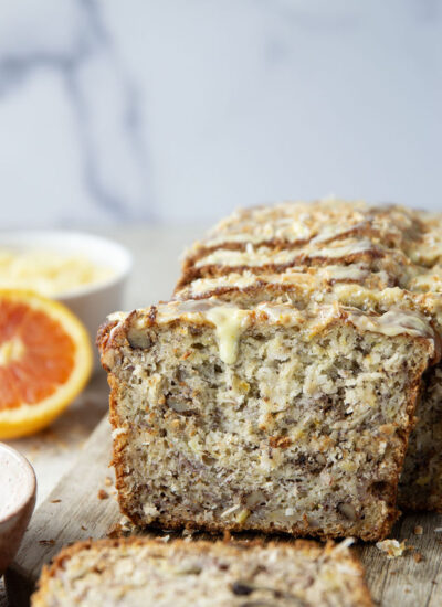 This tropical banana bread features a perfectly soft and dense texture and is packed with flaked coconut, lots of pineapple, and topped with a sweet citrus glaze.