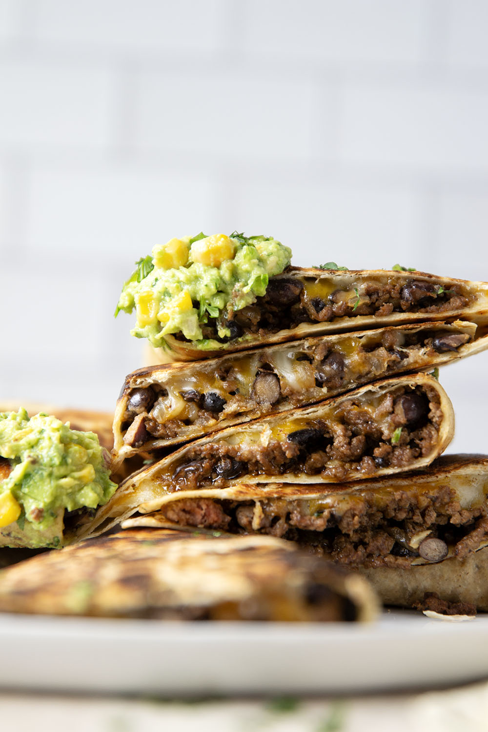 These ground beef quesadillas feature a cheesy ground beef black bean filling and lots of sweet corn guacamole for dipping.