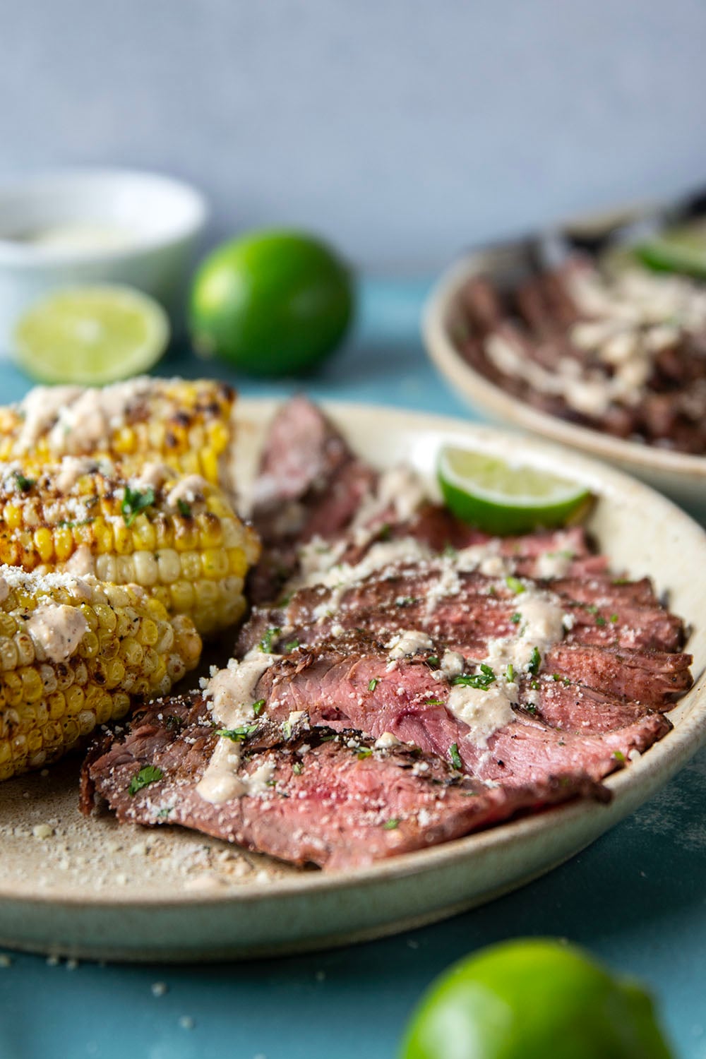 Spice-rubbed grilled flank steak and corn is an easy summer dish that pairs very well with a creamy chili lime sauce drizzled on top.