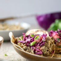 Spicy slow-cooked jerk chicken tacos feature fall-apart tender chicken cooked in a spicy homemade jerk sauce and topped with a fresh pineapple slaw.