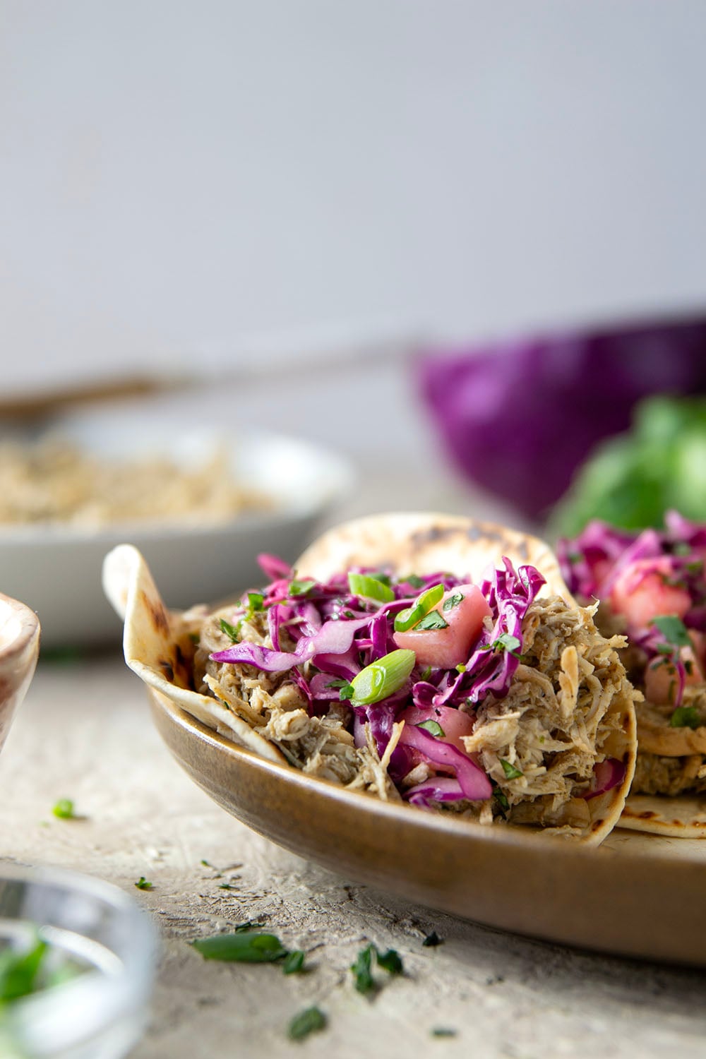 Spicy slow-cooked jerk chicken tacos feature fall-apart tender chicken cooked in a spicy homemade jerk sauce and topped with a fresh pineapple slaw.