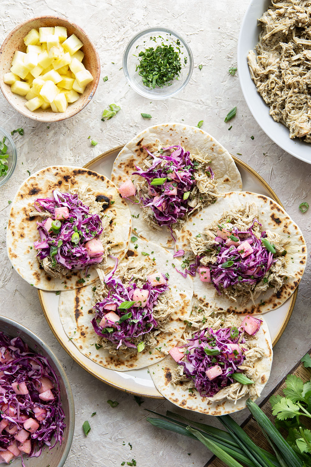 Spicy slow-cooked jerk chicken tacos feature fall-apart tender chicken cooked in a spicy homemade jerk sauce and topped with a fresh pineapple slaw.