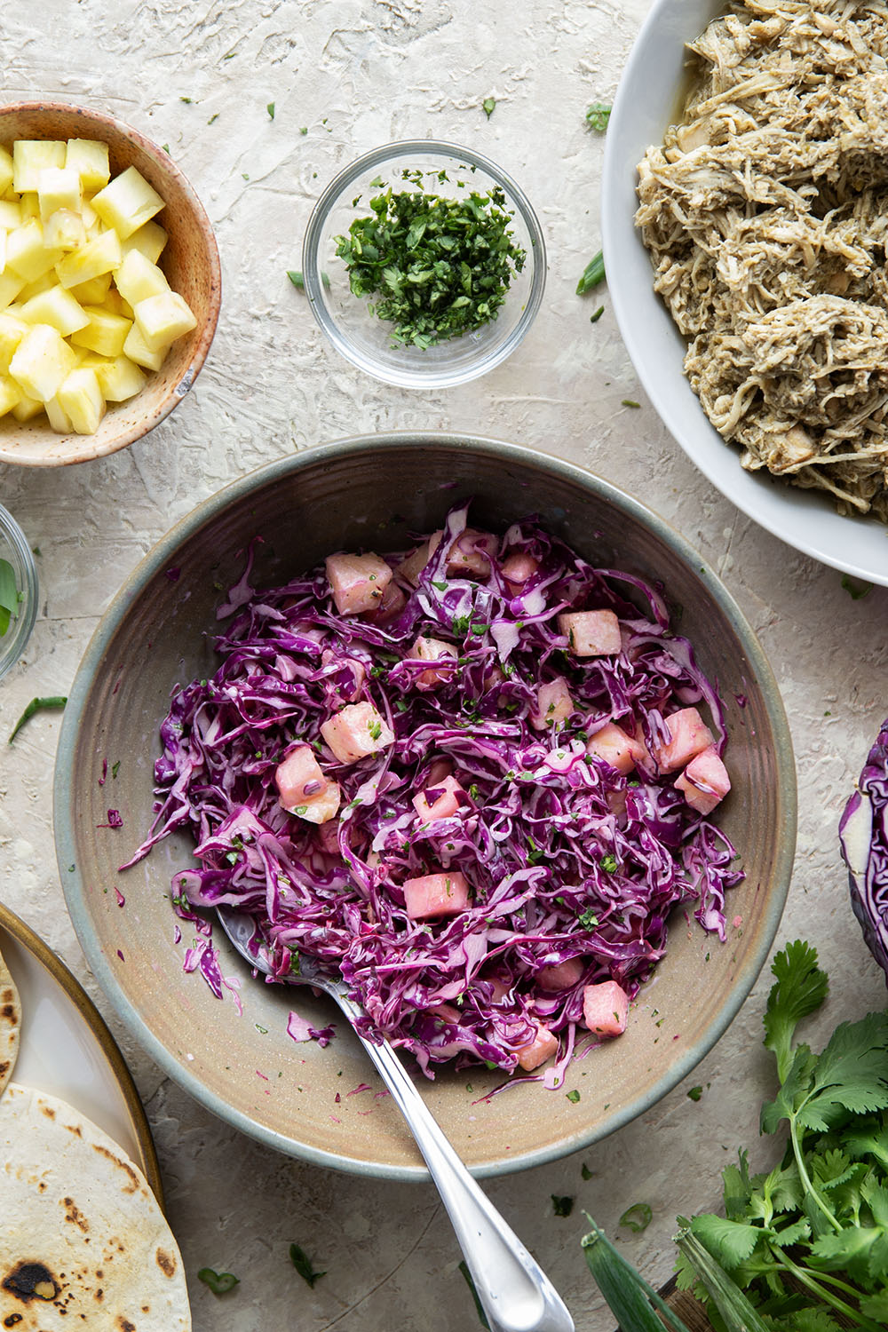 Spicy slow-cooked jerk chicken tacos feature fall-apart tender chicken cooked in a spicy homemade jerk sauce and topped with a fresh pineapple slaw.