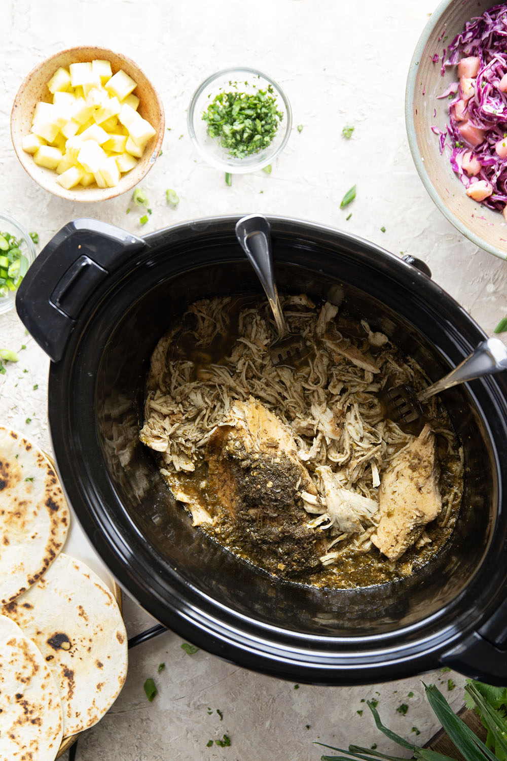 Spicy slow-cooked jerk chicken tacos feature fall-apart tender chicken cooked in a spicy homemade jerk sauce and topped with a fresh pineapple slaw.